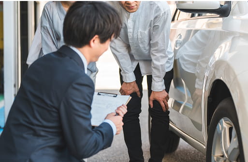 買取前に車の傷や状態を確認するスタッフとお客様