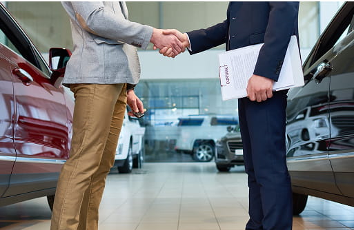 車の売買契約を締結する営業スタッフとお客様の握手